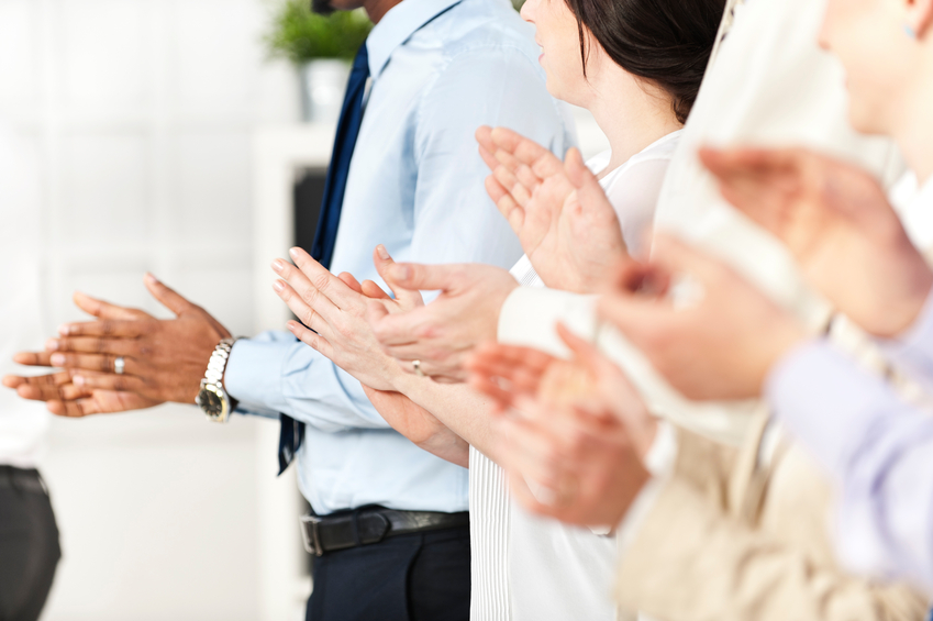 Multi ethnic coworkers standing in a line and applauding
